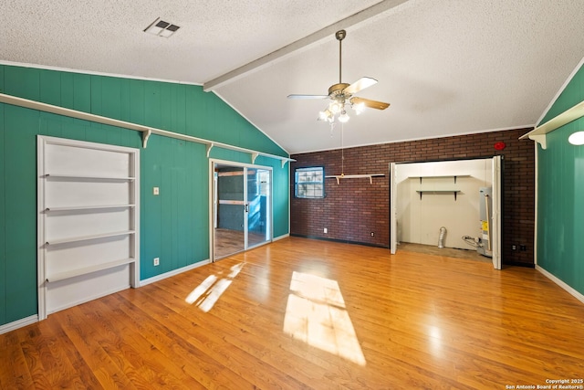 unfurnished bedroom with lofted ceiling with beams, visible vents, a textured ceiling, and wood finished floors