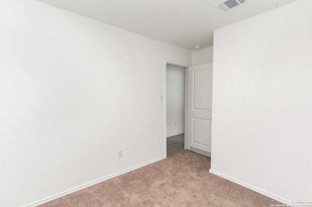 unfurnished room with light colored carpet, visible vents, and baseboards