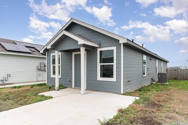 shotgun-style home with central AC and fence