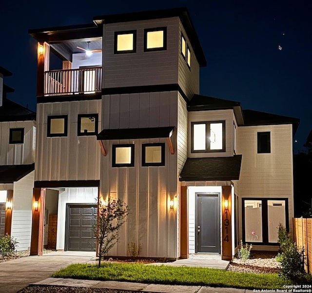 contemporary home featuring board and batten siding, concrete driveway, a balcony, and an attached garage