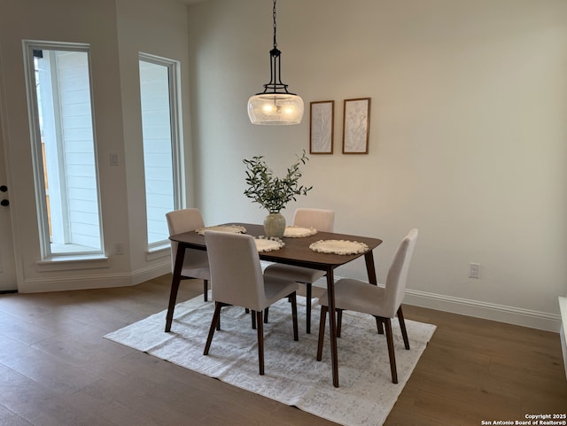 dining space featuring baseboards and wood finished floors