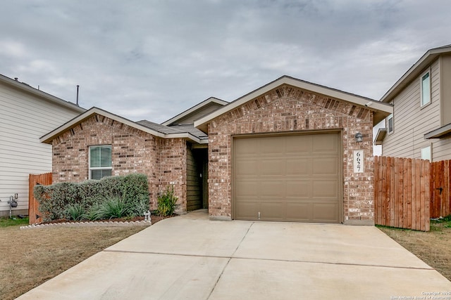 ranch-style home with a garage, brick siding, driveway, and fence