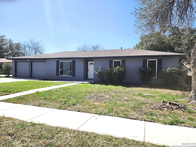 ranch-style house featuring a front yard, brick siding, driveway, and an attached garage