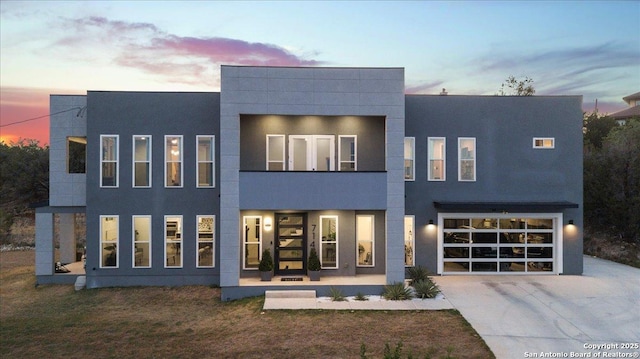 view of front facade featuring driveway, an attached garage, and stucco siding