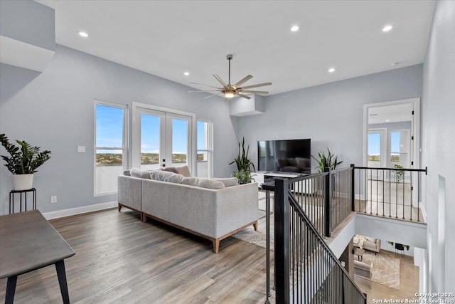 living area featuring french doors, a healthy amount of sunlight, and wood finished floors