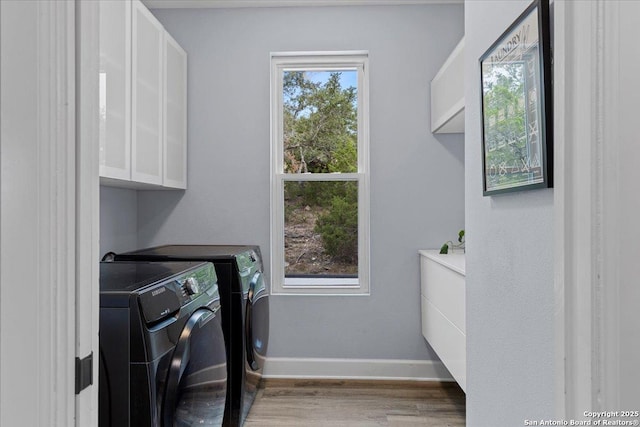 laundry room with cabinet space, baseboards, separate washer and dryer, and a wealth of natural light