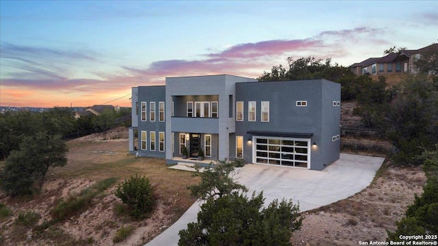 modern home with driveway, a garage, and stucco siding