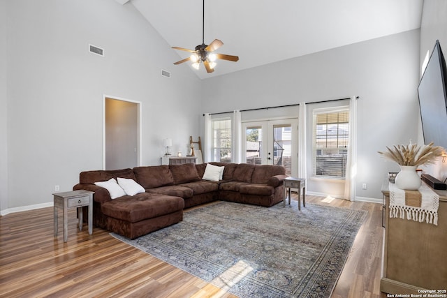 living room featuring high vaulted ceiling, french doors, visible vents, and wood finished floors