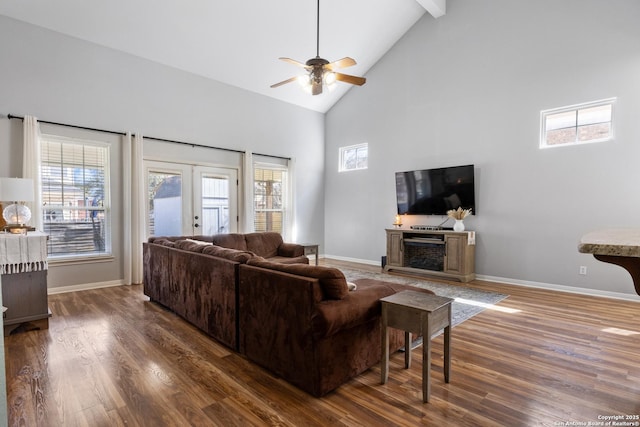 living area featuring high vaulted ceiling, french doors, baseboards, and wood finished floors