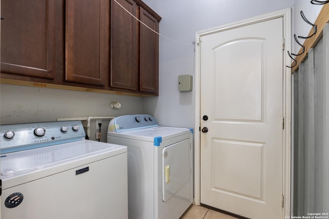 laundry room with cabinet space, light tile patterned floors, and independent washer and dryer