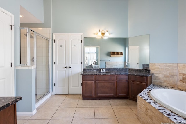 full bath featuring tile patterned flooring, a shower stall, a bath, and vanity