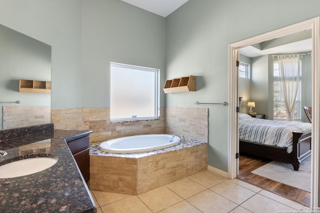 full bathroom featuring ensuite bathroom, vanity, a bath, and tile patterned floors