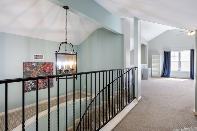 hall featuring lofted ceiling, carpet, visible vents, and an upstairs landing