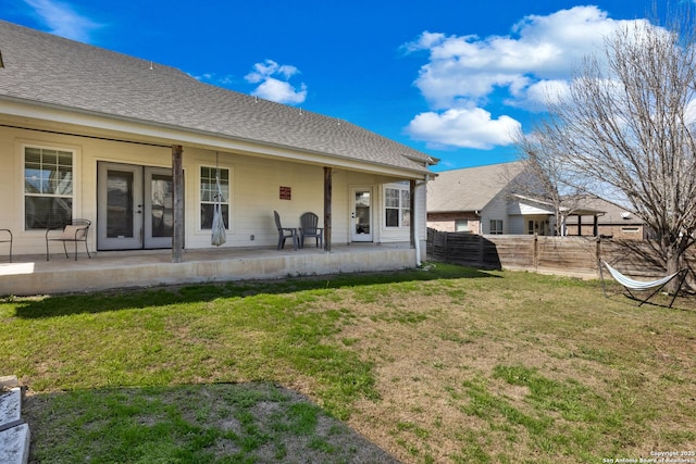 back of property featuring a patio, a yard, roof with shingles, and fence