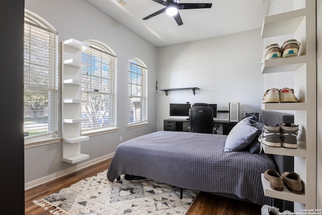 bedroom with ceiling fan, baseboards, and wood finished floors