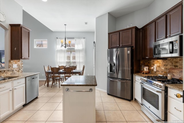 kitchen with appliances with stainless steel finishes, stone counters, and light tile patterned flooring