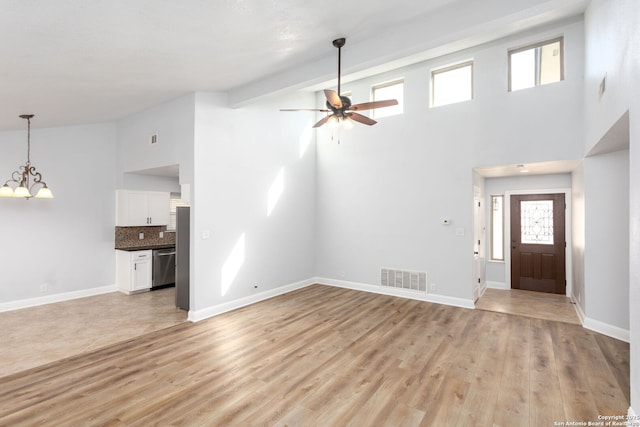 unfurnished living room featuring beam ceiling, visible vents, light wood-style floors, baseboards, and ceiling fan with notable chandelier