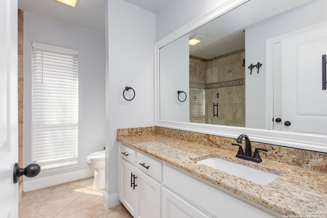 full bath featuring tile patterned flooring, toilet, vanity, baseboards, and a stall shower