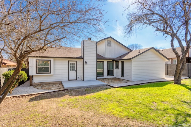 back of property featuring a patio area, fence, a chimney, and a lawn