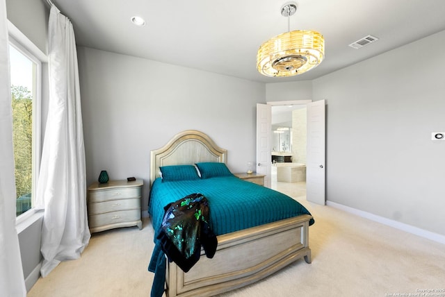 carpeted bedroom featuring ensuite bathroom, visible vents, and baseboards