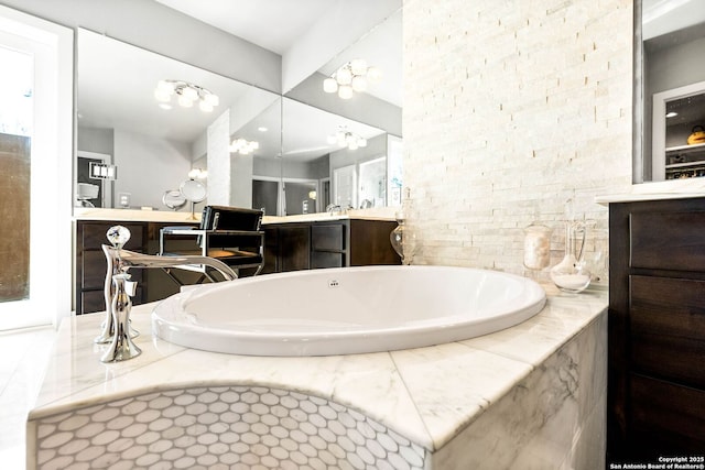 bathroom featuring a garden tub and vanity