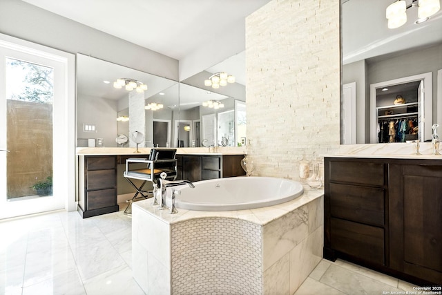 full bath featuring a walk in closet, a garden tub, and vanity