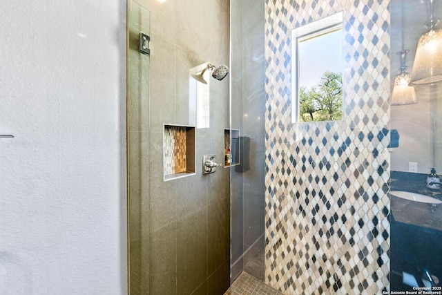 full bath featuring a tile shower and vanity