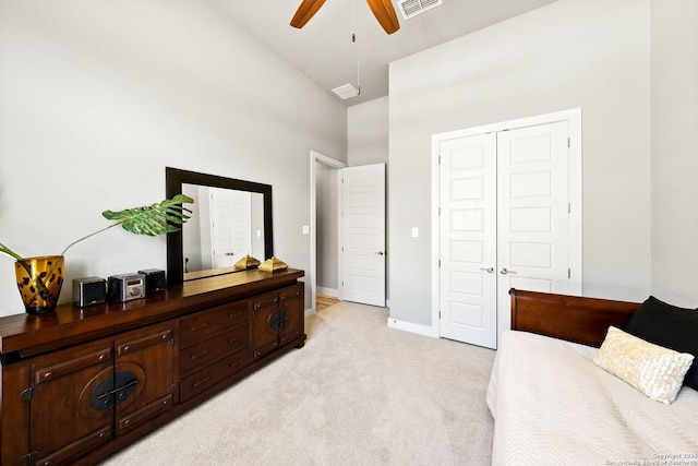 bedroom featuring high vaulted ceiling, light carpet, visible vents, baseboards, and a closet