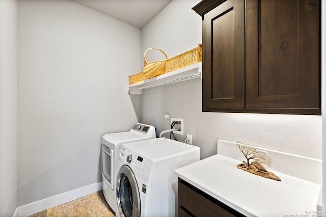 laundry area featuring independent washer and dryer, cabinet space, and baseboards