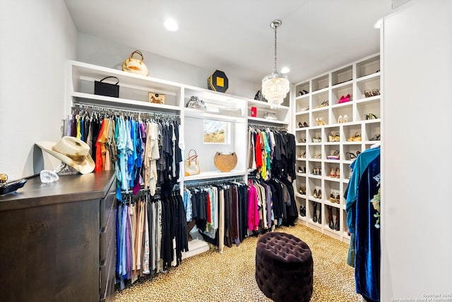 walk in closet featuring carpet floors and a notable chandelier