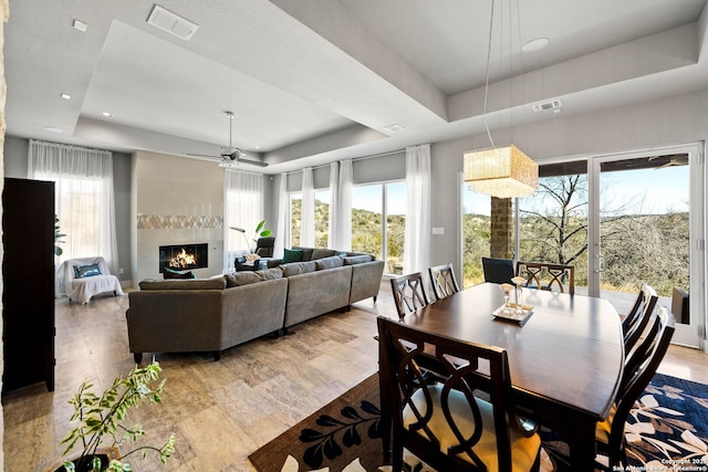 dining space featuring a healthy amount of sunlight, visible vents, and a raised ceiling