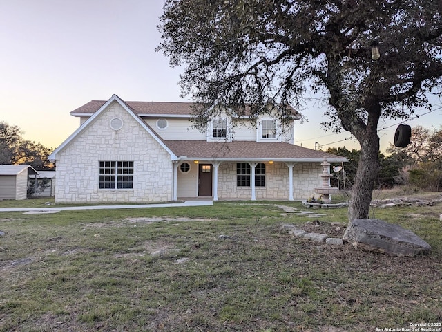 traditional home featuring a shingled roof and a front yard