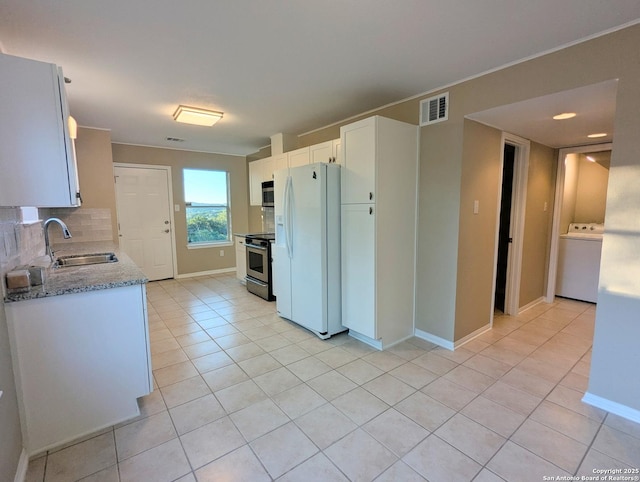 kitchen featuring stainless steel appliances, a sink, visible vents, decorative backsplash, and washer / clothes dryer