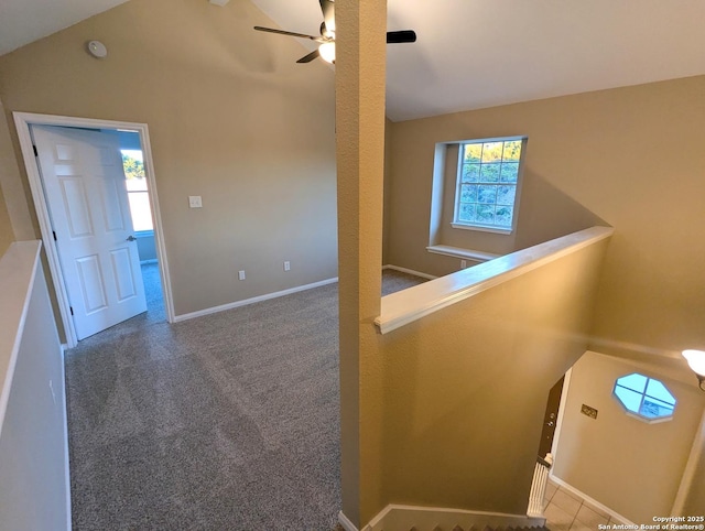 interior space featuring baseboards, vaulted ceiling, carpet flooring, and an upstairs landing