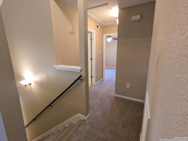 hallway featuring carpet, a textured wall, attic access, an upstairs landing, and baseboards