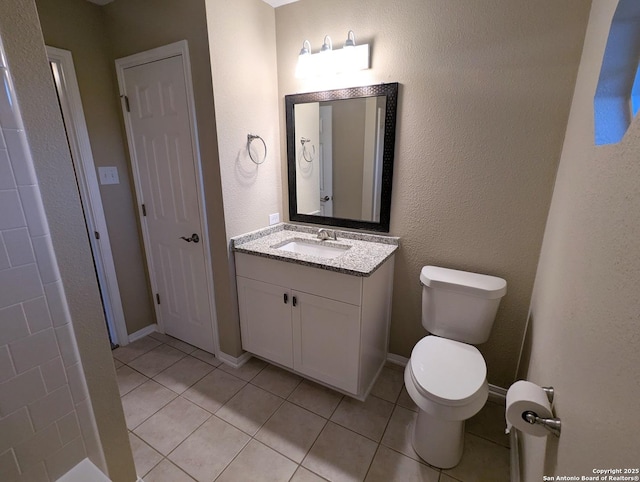 bathroom with baseboards, vanity, toilet, and tile patterned floors