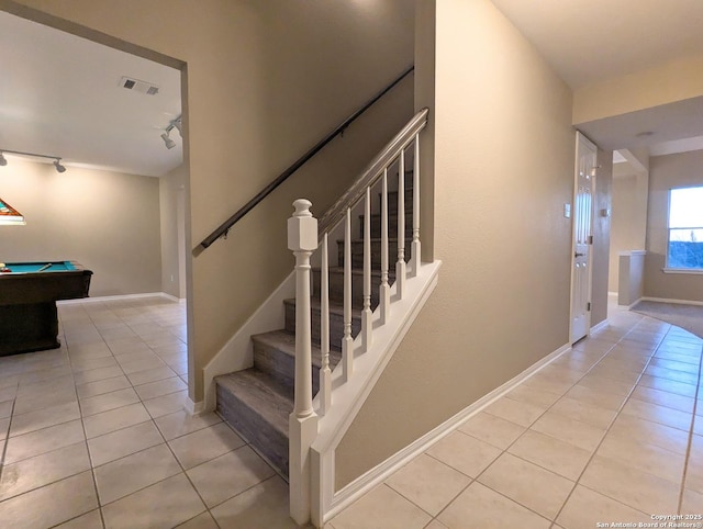 staircase with track lighting, visible vents, baseboards, and tile patterned floors