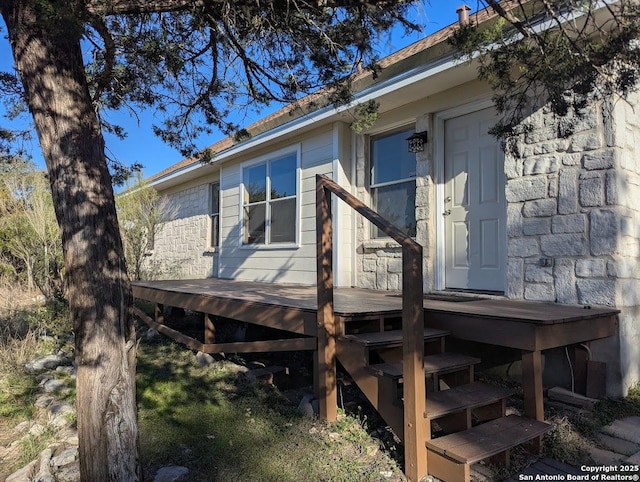 exterior space with stone siding and a deck