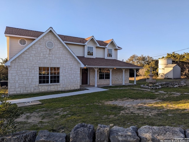 traditional-style house with a shingled roof and a front yard