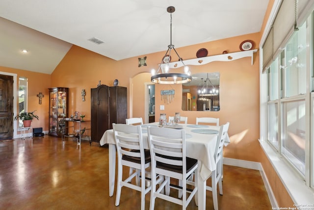 dining area with visible vents, finished concrete flooring, baseboards, lofted ceiling, and a notable chandelier