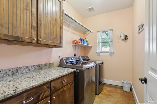 laundry area with baseboards, cabinet space, independent washer and dryer, and visible vents