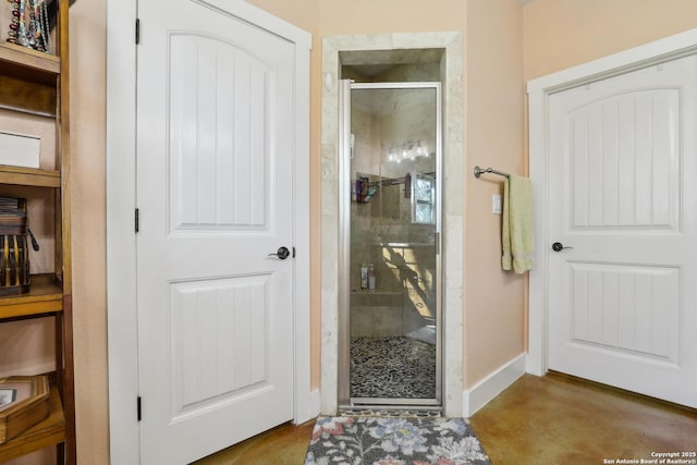 bathroom with baseboards and a shower stall