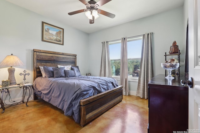 bedroom with ceiling fan, baseboards, and finished concrete floors