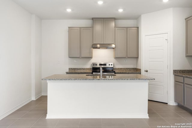 449 Horizon Pl, Seguin, TX 78155 - kitchen with under cabinet range hood, gray cabinetry, an island with sink, a sink, and light stone countertops