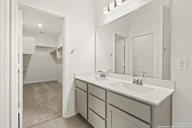 449 Horizon Pl, Seguin, TX 78155 - bathroom featuring double vanity, a walk in closet, tile patterned floors, and baseboards