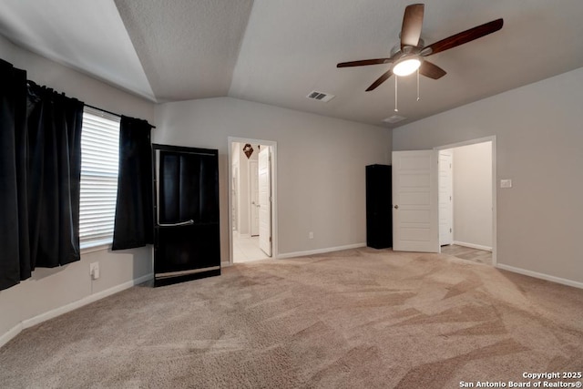 unfurnished bedroom featuring carpet, visible vents, vaulted ceiling, and baseboards