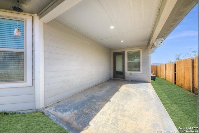 doorway to property with a lawn, a patio area, and fence