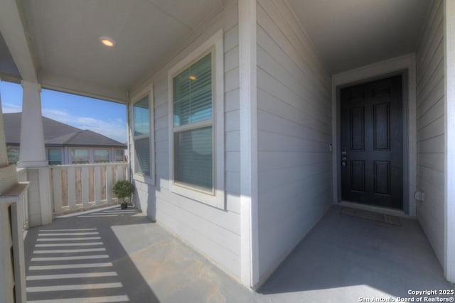 view of exterior entry featuring covered porch