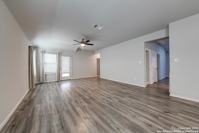 spare room featuring a ceiling fan, visible vents, baseboards, and wood finished floors