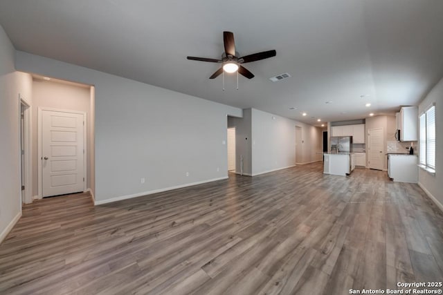 unfurnished living room with a ceiling fan, baseboards, wood finished floors, and recessed lighting